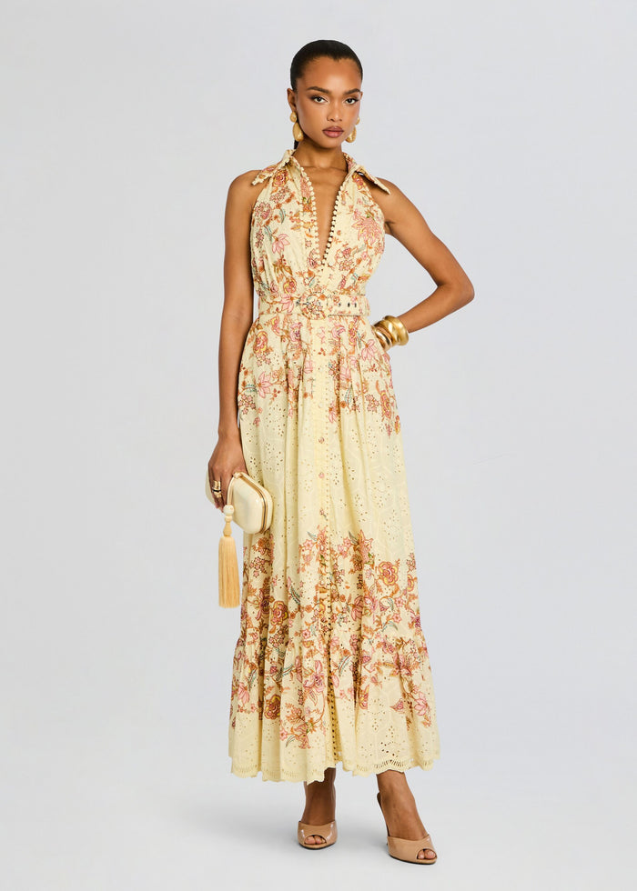 Full-length shot of a model in a cream floral Riah Long Dress with a belted waist and scalloped eyelet hem media 1 of 5