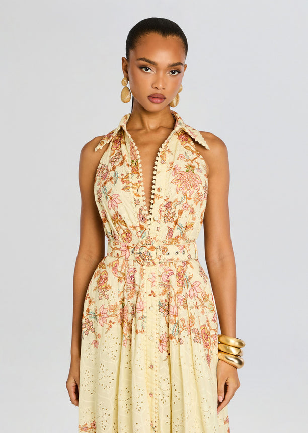 Cream halter neck maxi dress with pastel floral print and matching belt at the waist.