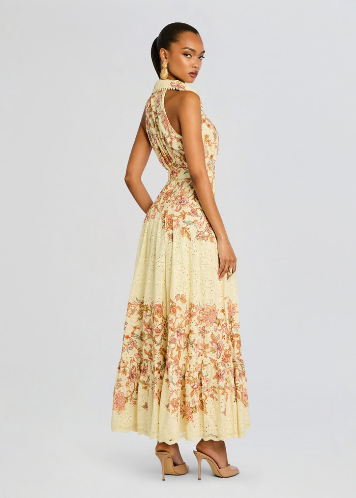 Cream maxi dress with intricate pink floral embroidery and eyelet hem, model in profile. media 4 of 5