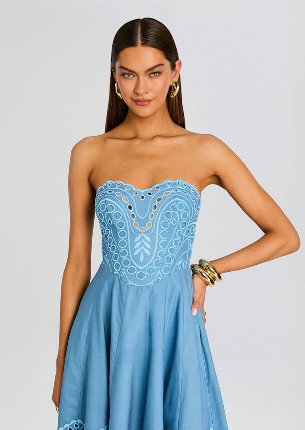 Model wearing a strapless blue Marlin Long Dress with a scalloped embroidered bodice and a full flowing skirt