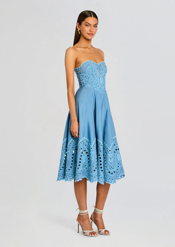 Model wearing blue Marlin Long Dress with strapless neckline and embroidered scalloped hem on the midi skirt