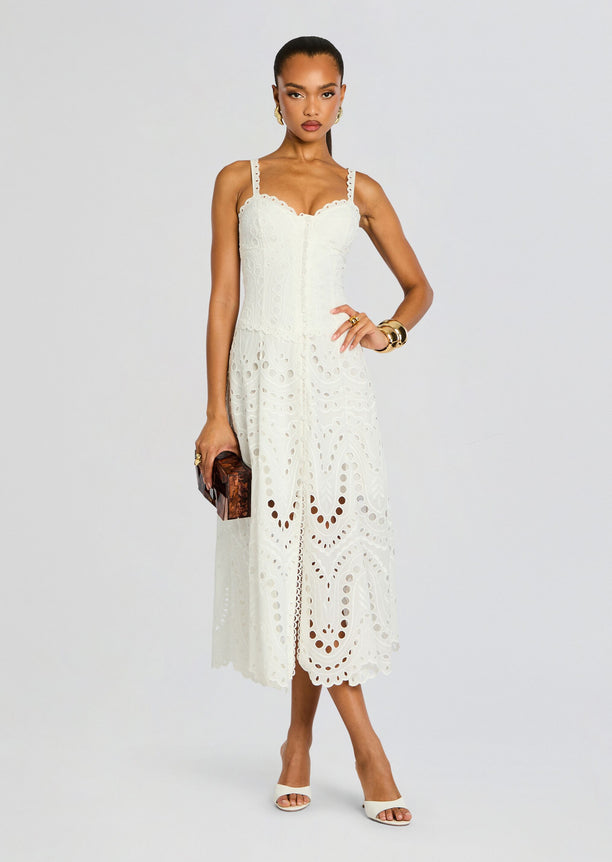 Model in a white Solace Long Dress with scalloped eyelet bodice straps and a full embroidered skirt