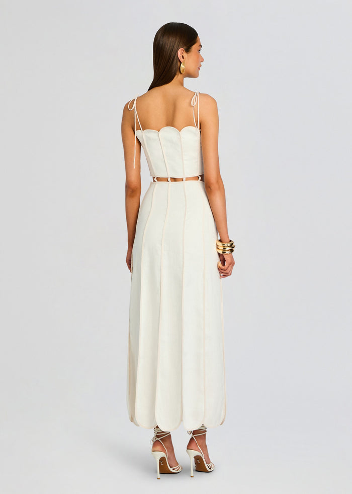 Back view of ivory Malta Dress with a structured corset bodice and a long cream skirt featuring thin tie straps media 3 of 4