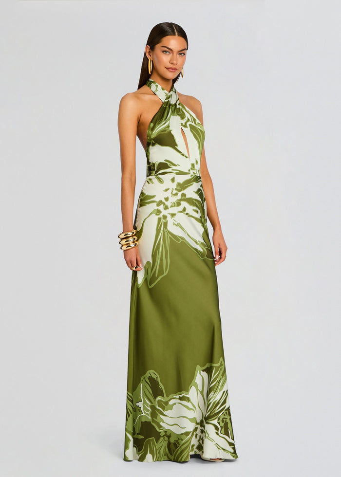 Model wearing the Avo Maxi Dress in olive green satin with bold botanical print along the hem. media 3 of 5