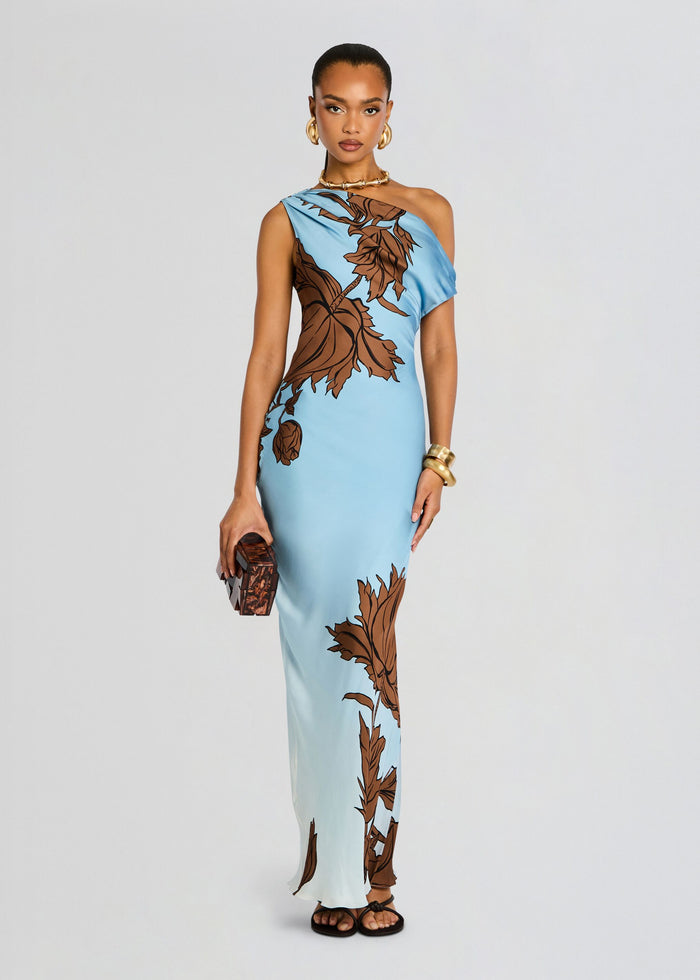 Cady One Shoulder Maxi Dress full length on model with sky blue fabric brown leaf print and gold accessories. media 3 of 5