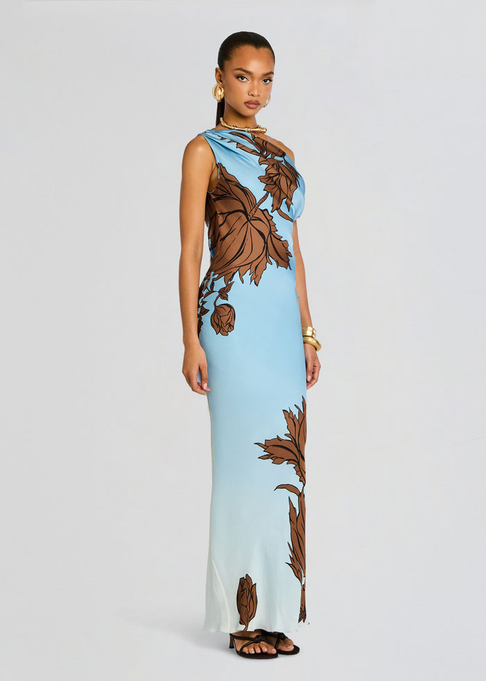 Model wearing Cady One Shoulder Maxi Dress shown in a side angle with blue fabric and large brown botanical print. media 4 of 5
