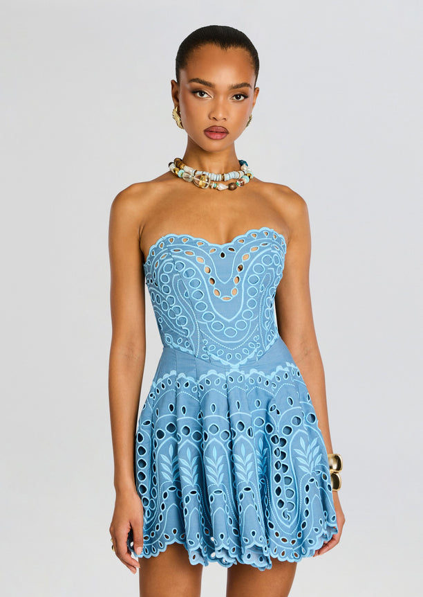 Front view of a strapless light blue Bail Short Dress with ornate eyelet pattern and a flared skirt