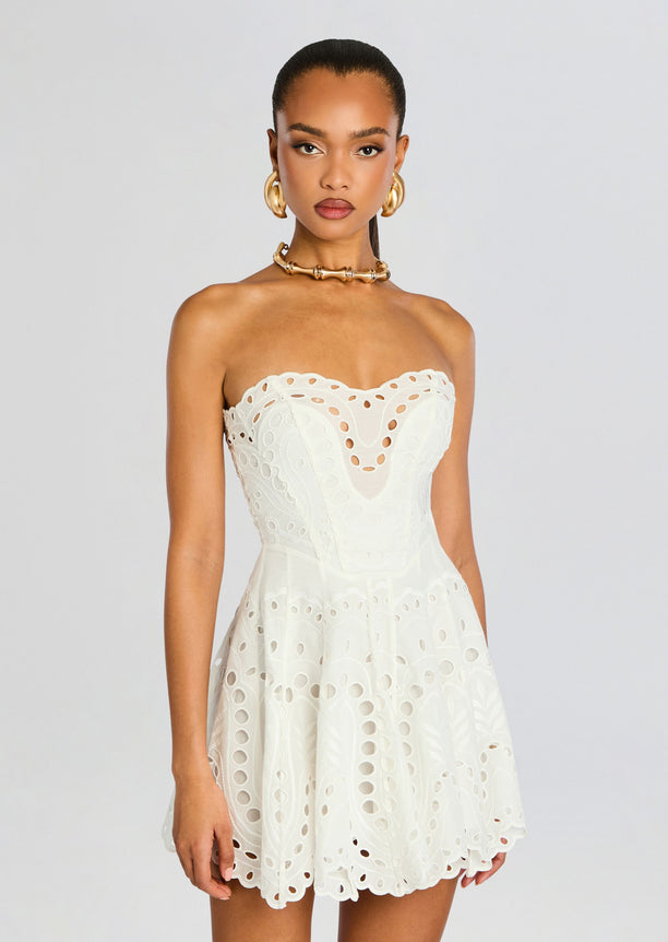 White Bail Short Dress strapless with eyelet cutouts and scalloped edges on a model.