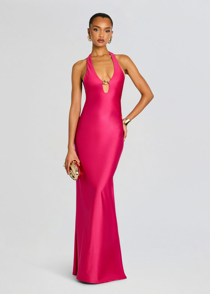 Model in Sienna Maxi Dress a vivid pink halter gown with a center gold ring accent. media 1 of 4