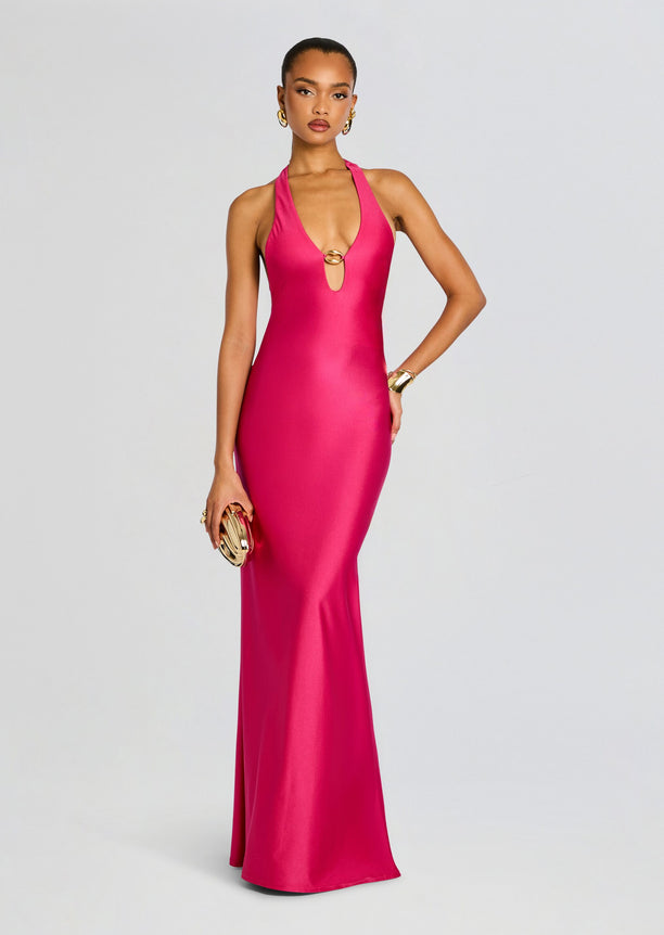 Model in Sienna Maxi Dress a vivid pink halter gown with a center gold ring accent.