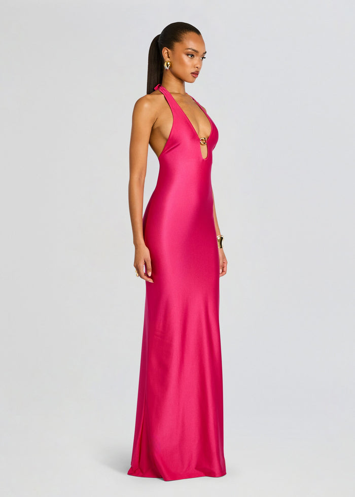 Profile view of a model wearing the Sienna Maxi Dress in bright pink a sleek halter gown. media 2 of 4