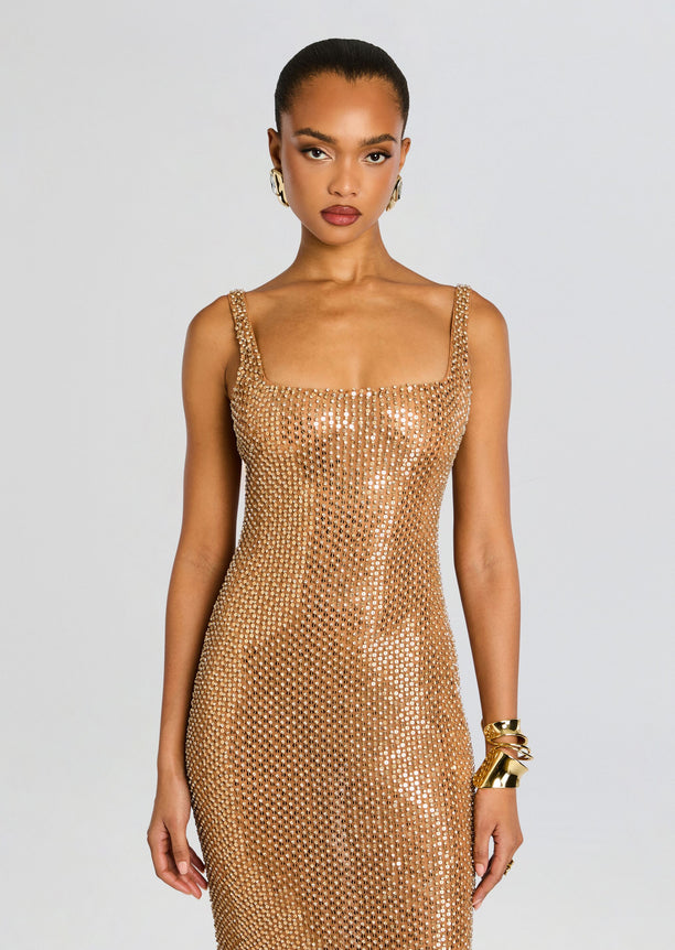 Front view of Xiomara Sequin Dress highlighting the gold sequined fabric and strap detailing on a standing model