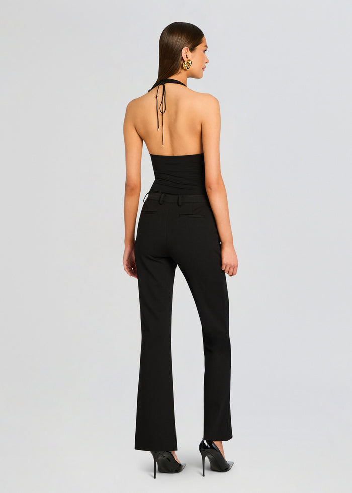 Back view of a model in Kristen Perfect Work Trouser with a black halter top tied at the neck. media 5 of 6