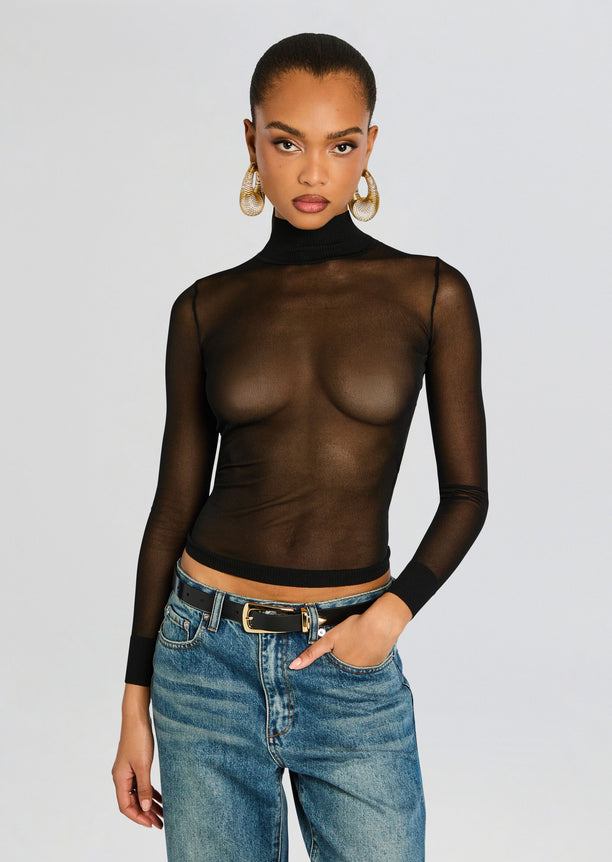Lainey Top sheer black turtleneck worn with blue jeans and gold hoop earrings.
