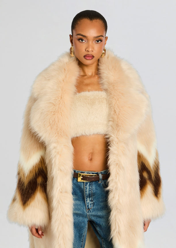 Front view of model wearing Magali beige faux fur coat with oversized collar and belt over denim jeans