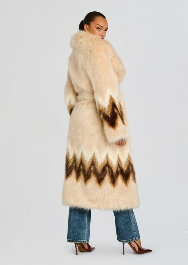 Side view of Magali beige faux fur coat with dark brown chevron pattern along the hem