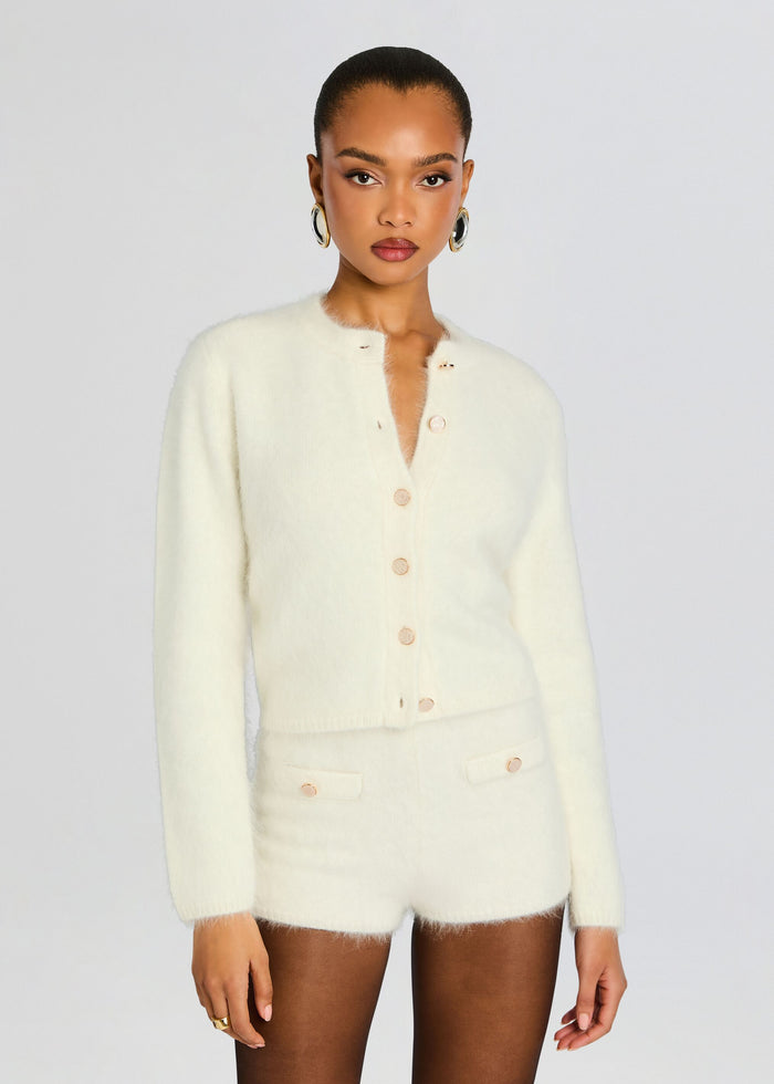 Model wearing a cream Medora Cardigan with matching shorts in a soft knit and peach buttons media 1 of 5