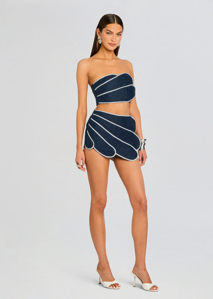 Full-length front view of a model wearing navy Sango bandeau top and matching navy shorts with white piping media 4 of 5