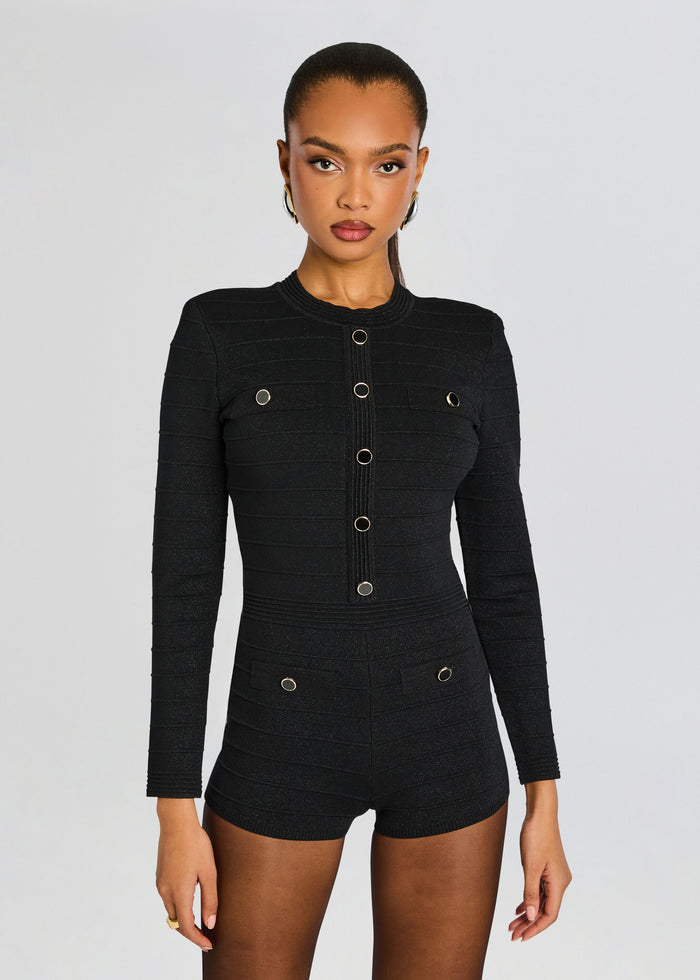 Close up of model wearing Tesni Knit Romper black textured long sleeve with gold ring buttons along the front media 5 of 6