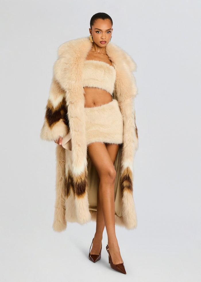Model wearing Vada Faux Fur Bandeau set featuring a cream bandeau top, matching mini skirt, and a voluminous cream fur coat. media 7 of 7