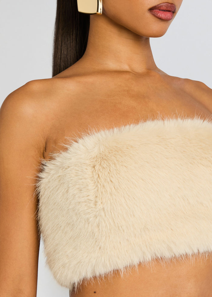 Close-up of strapless cream faux fur bandeau across the model’s chest and shoulder showing the fluffy texture. media 3 of 7