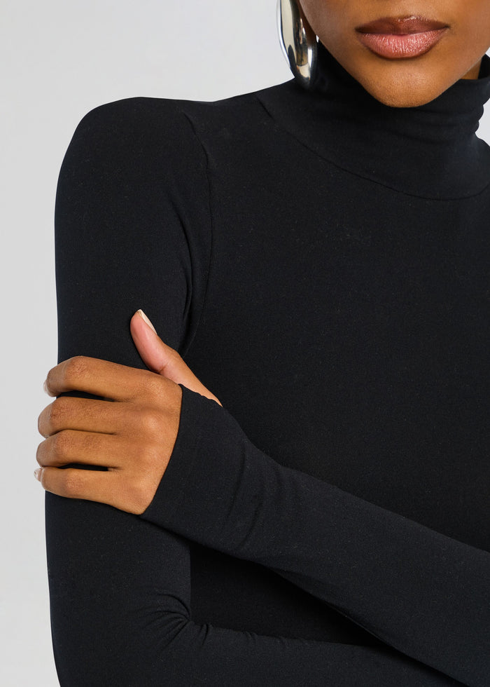 Close-up of a model wearing a black Ballet Turtleneck Bodysuit with crossed arms. media 3 of 6