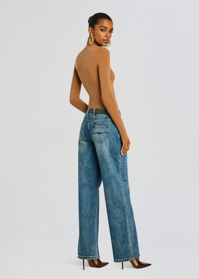 Back view of model in tan Ballet Turtleneck Bodysuit with jeans and brown heeled pumps media 5 of 6