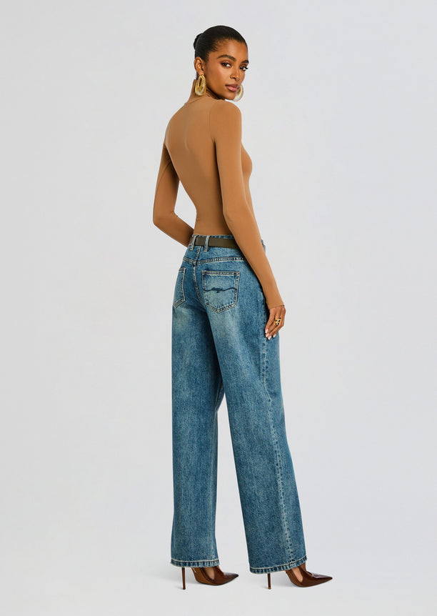 Back view of model in tan Ballet Turtleneck Bodysuit with jeans and brown heeled pumps