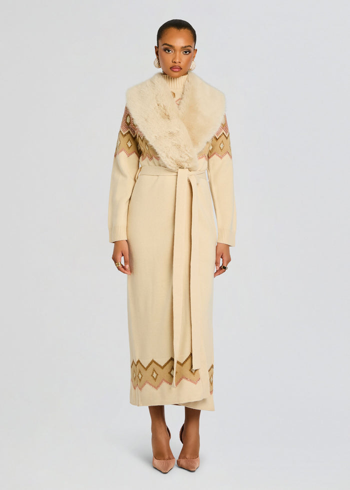 Full-length model wearing cream Basalt Knit Cardigan belted at the waist with a geometric hem and fur stole media 3 of 6