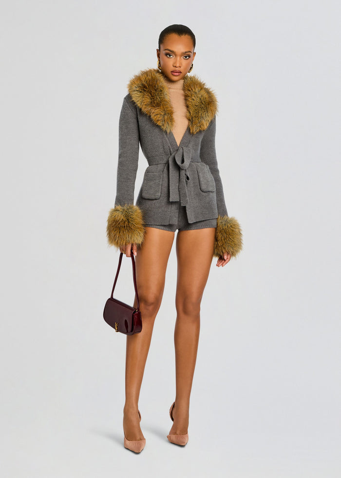 Chantelle Lilian Knit Short set on a model with fur trim at the collar and cuffs belt at the waist carrying a burgundy handbag and wearing nude heels media 2 of 6