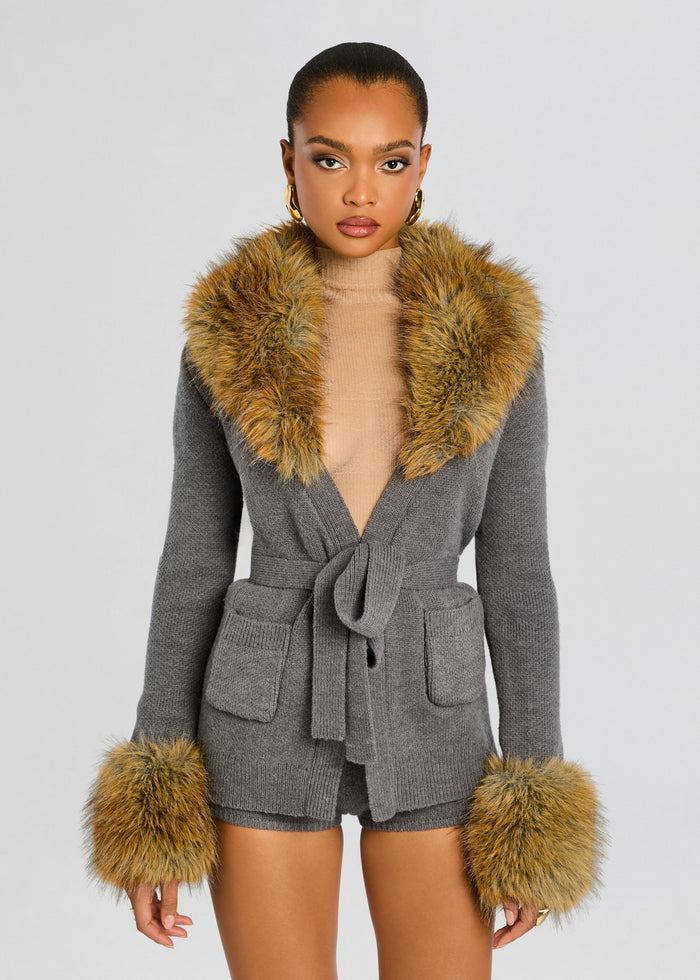 Model in grey knit belted robe with a wide golden fur collar and fur cuffs media 1 of 6