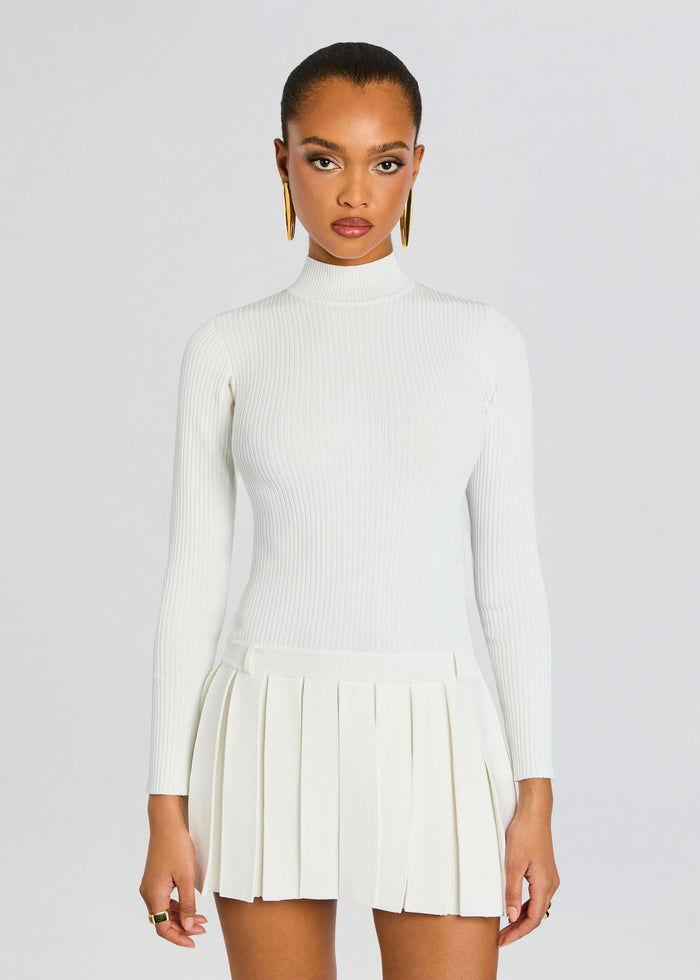 Front view of a white ribbed knit dress with a high neckline and pleated mini skirt. media 5 of 5