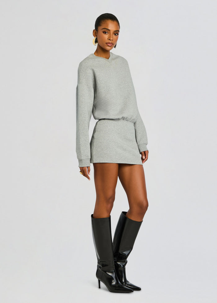 Model wearing the gray Dionne Mini Dress with an oversized sweater style top and a cinched waist paired with knee high black boots media 3 of 5