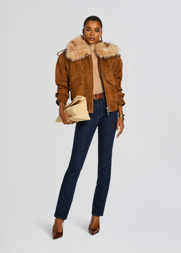 Front view of model in caramel suede jacket with fur collar, dark jeans and beige clutch. media 6 of 7