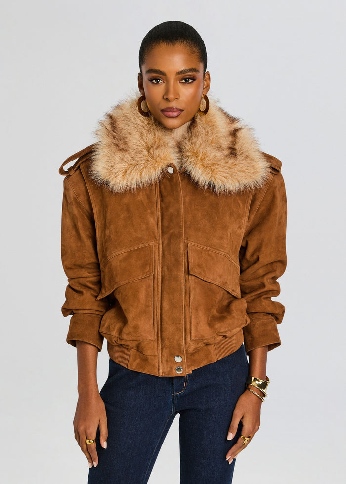 Front view of model wearing caramel suede jacket with oversized fur collar, dark jeans, and gold jewelry. media 7 of 7