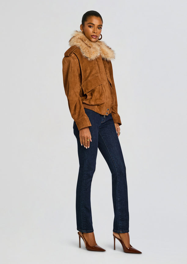 Full body shot of a model wearing the Erynn Suede Jacket with fur collar, dark jeans and brown high heels.