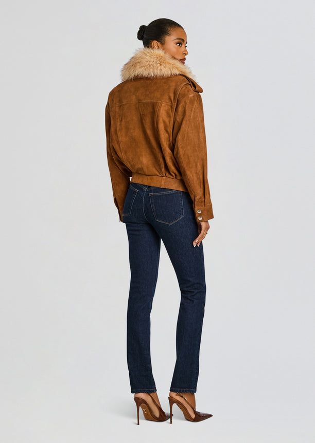 Back view of caramel suede Erynn jacket with fluffy fur collar, paired with dark jeans and brown heels.
