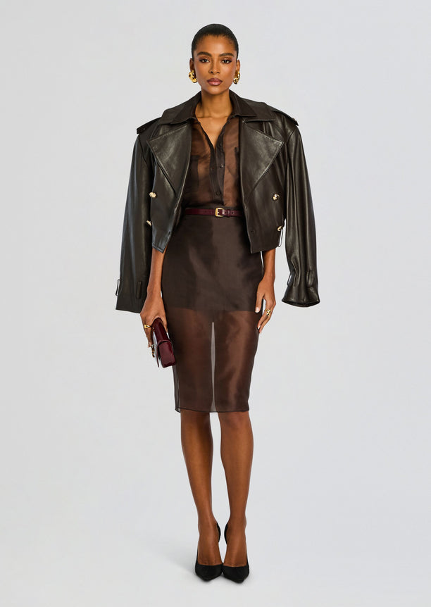 Model in a brown sheer silk midi skirt paired with a sheer top and a black oversized leather jacket