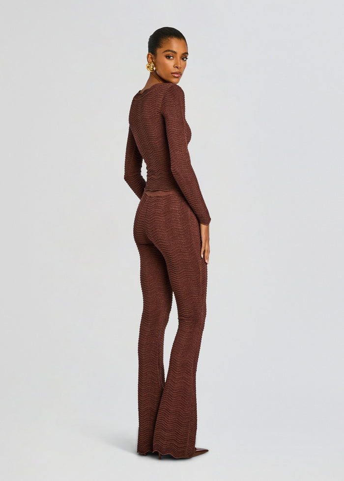 Back view of the model in a brown Joliet rib knit set with a fitted top and flared pants. media 5 of 5