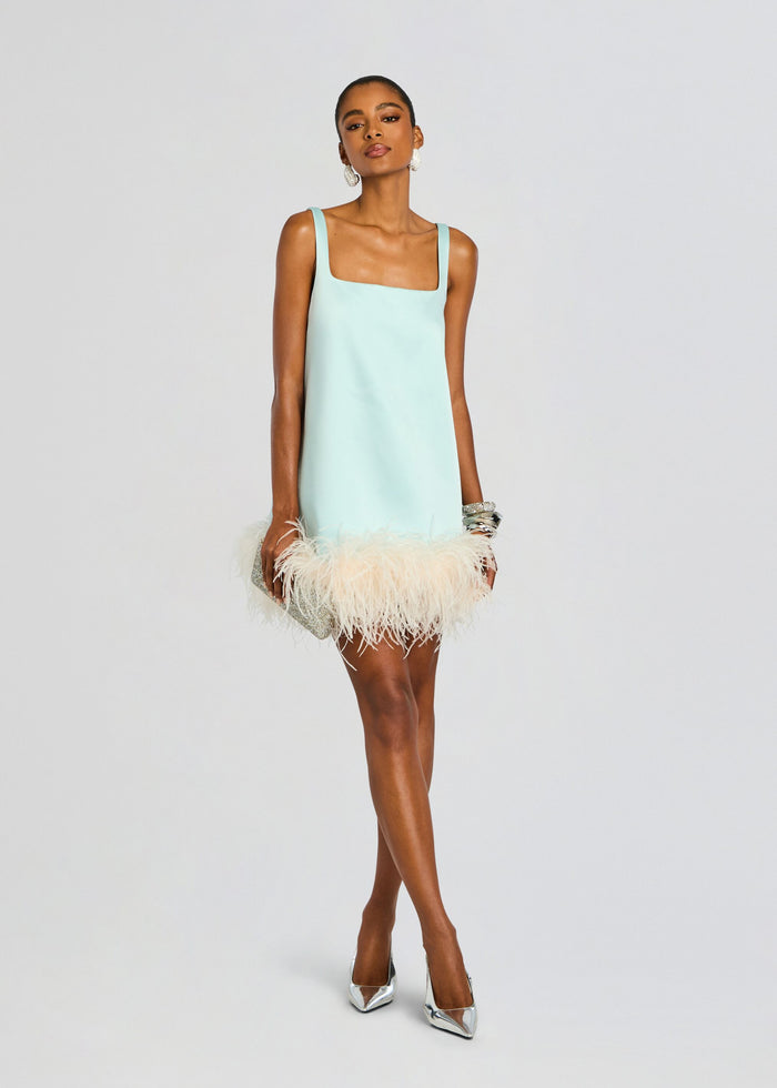 Model in mint slip dress with square neckline and cream feathered hem, holding a silver clutch. media 1 of 6