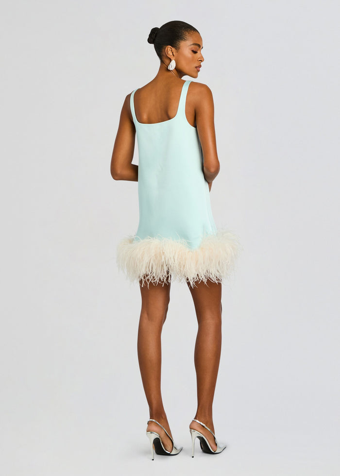 Back view of a model in a mint Ragna Feather Dress with shoulder straps and fluffy feather hem, wearing silver stiletto sandals. media 5 of 6