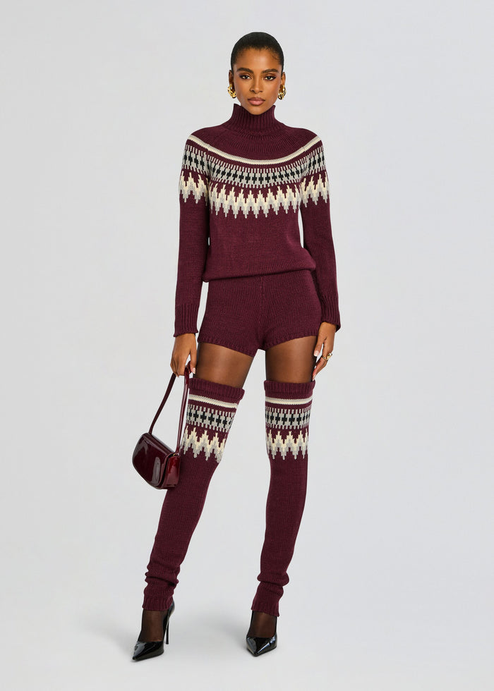 Front view of model in burgundy Rocky Knit Romper with matching thigh-high socks, black patent heels, and a burgundy bag. media 5 of 5