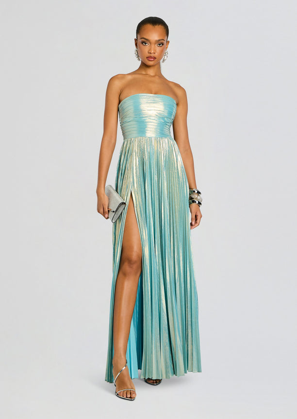 Full-length turquoise metallic strapless Sevyn Dress with a high slit worn by a model holding a silver clutch