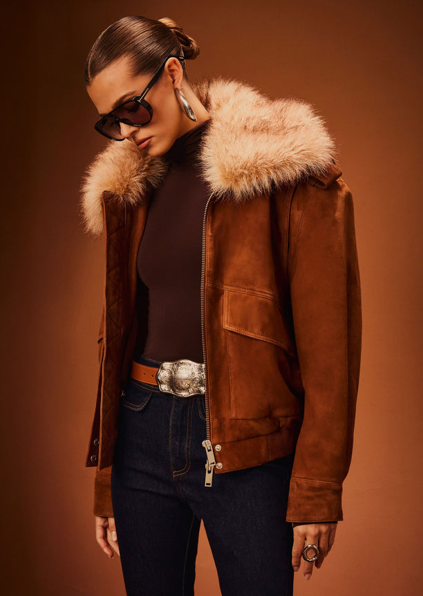 Model wearing Erynn Suede Jacket with a cream fur collar over a black top and dark jeans.