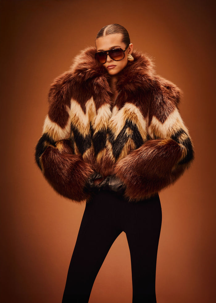 Model wears Ismay Faux Fur Bomber featuring a bold brown cream and black chevron fur pattern. media 2 of 6