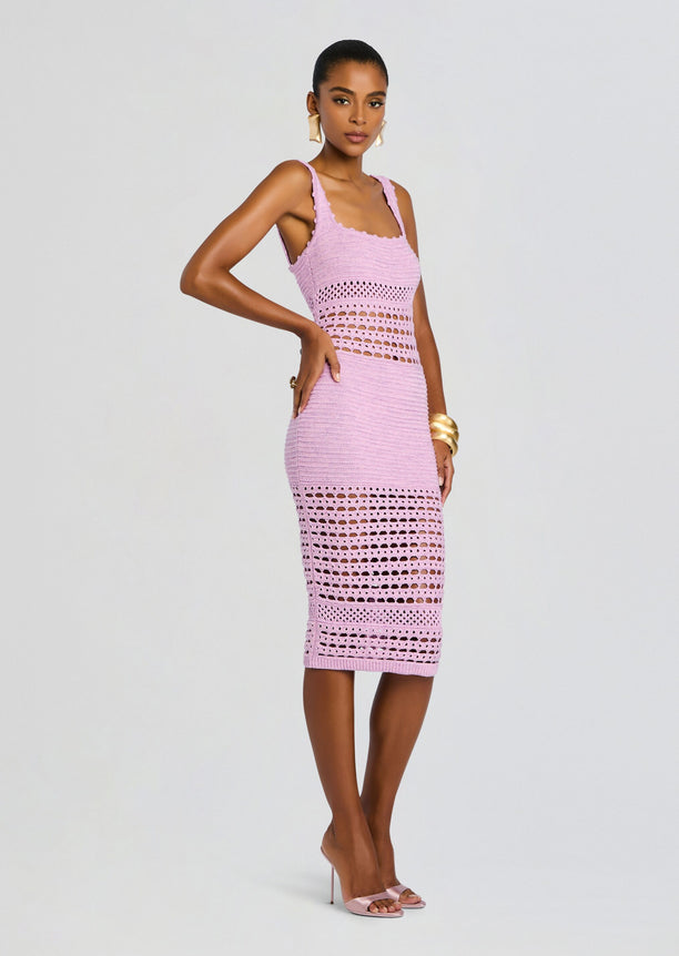 Full-length side view of a model wearing the lilac knit crochet midi dress with openwork panels and pink heels