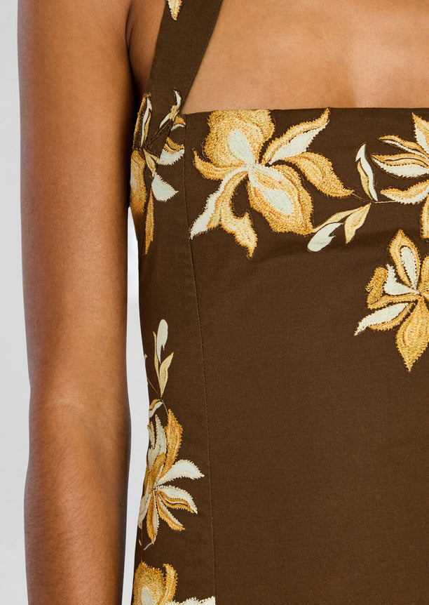 Close-up of brown halter dress bodice with yellow floral embroidery around the neckline.