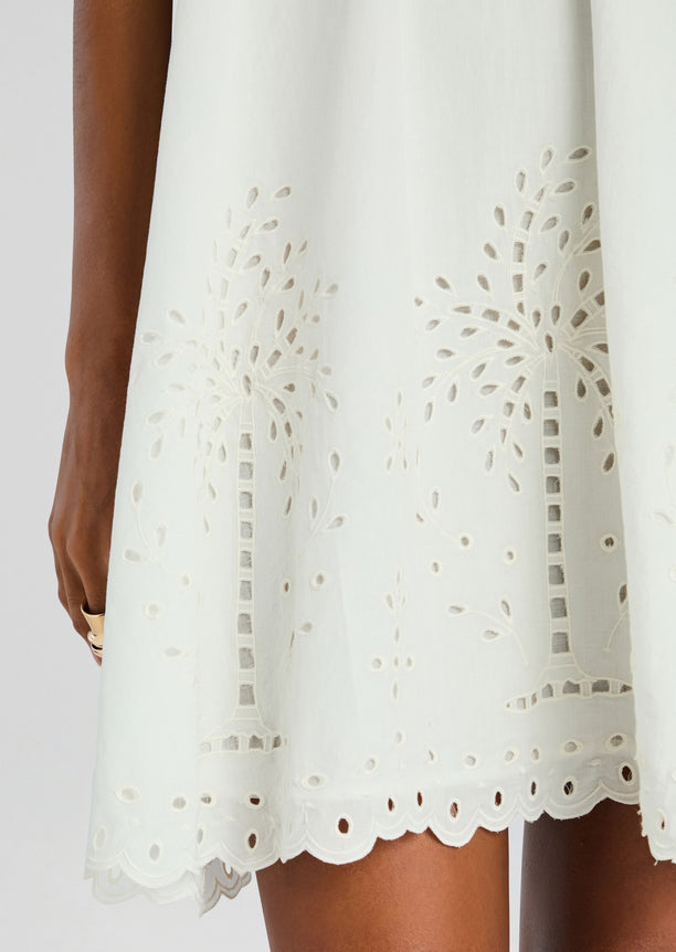 Close-up of white Bagh Halter Mini Dress fabric showing eyelet embroidery and scalloped hem.
