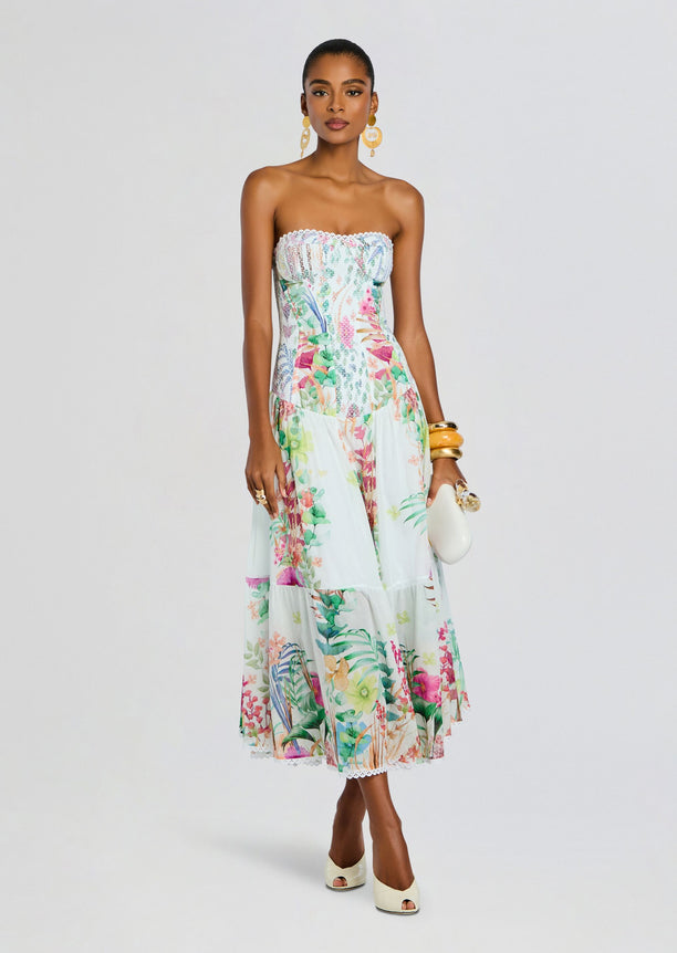 Model in a strapless Illyr Long Dress with a tropical floral print and lace trim at the hem.