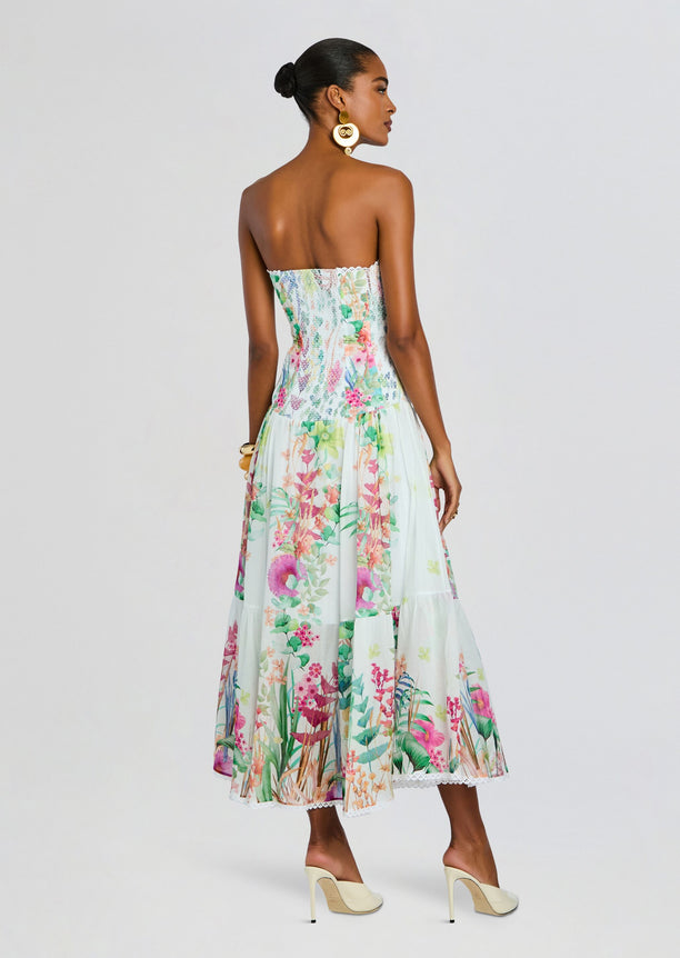 Back view of Illyr Long Dress showing a smocked bodice and flowing pastel floral skirt.